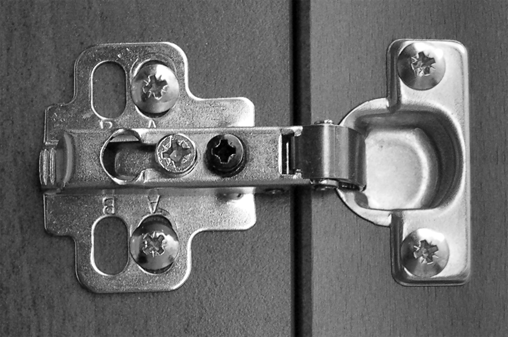 A concealed cabinet hinge photographed in close detail